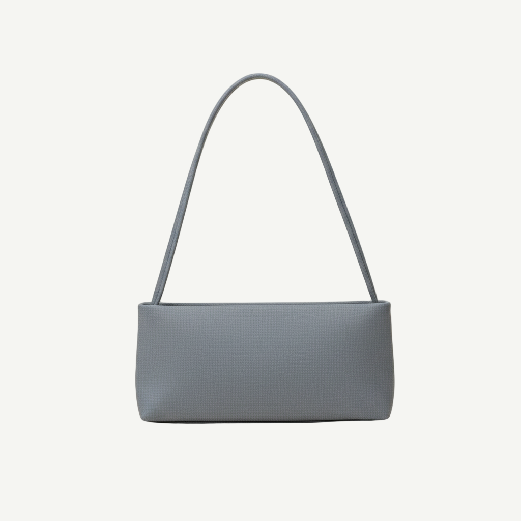 Bolso Minimal Blue Mist en material vegano premium, silueta rectangular rígida y asa alargada. Ligero, estructurado y minimalista, ideal para looks urbanos y elegantes.