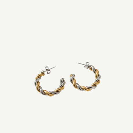Pendientes Twist Duo bicolor dorado y plateado, diseño trenzado y acabado pulido. Ligeros, elegantes y versátiles para looks de día o noche.
