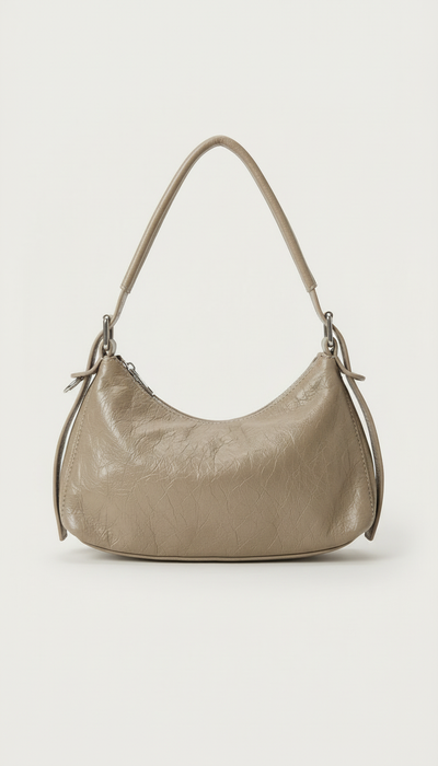 Bolso Crescent Taupe en PU vegano premium con textura arrugada y silueta curva. Ligero, flexible y moderno, ideal para uso diario y looks casual.