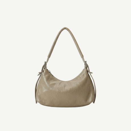 Bolso Crescent Taupe en PU vegano premium con textura arrugada y silueta curva. Ligero, flexible y moderno, ideal para uso diario y looks casual.