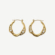 Pendientes Aura Pearl Hoops en latón con baño de oro y microperlas engastadas. Ligeros, elegantes y versátiles para looks diarios o especiales.