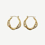 Pendientes Aura Pearl Hoops en latón con baño de oro y microperlas engastadas. Ligeros, elegantes y versátiles para looks diarios o especiales.