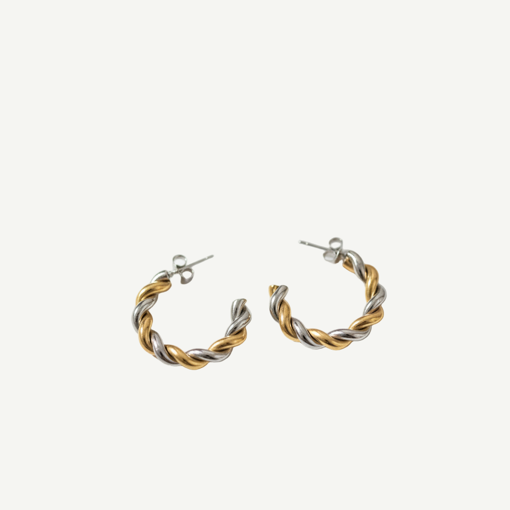 Pendientes Twist Duo bicolor dorado y plateado, diseño trenzado y acabado pulido. Ligeros, elegantes y versátiles para looks de día o noche.